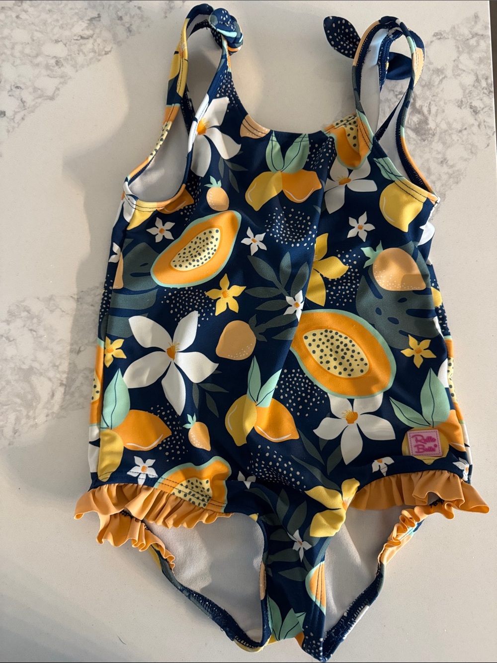 Ruffle Butts Navy Blue Tropical Fruit One-Piece Swimsuit with Yellow Ruffle Trim